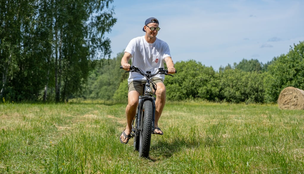 a man riding an electric bicycle in a field