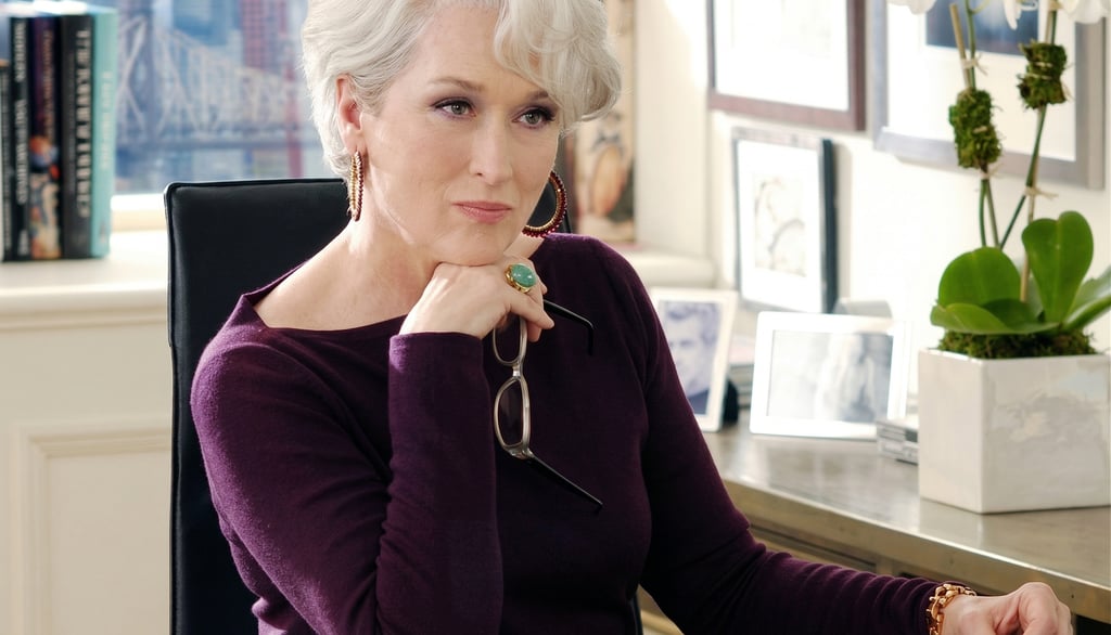 Miranda Priestly en su oficina con expresión analítica, representando el control y la exigencia en la industria de la moda