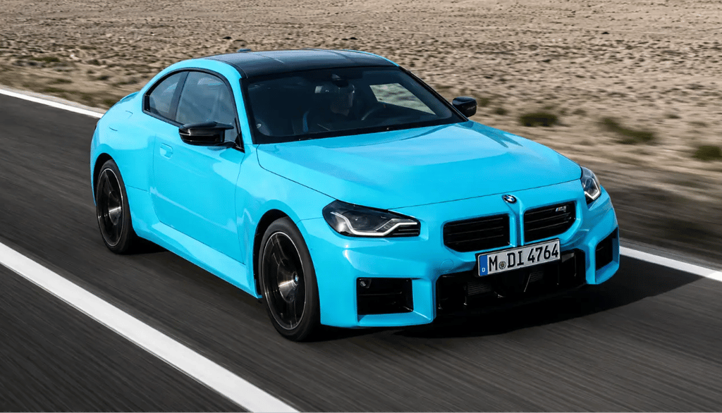 BMW M2 xDrive azul acelerando em estrada com tração integral e visual esportivo