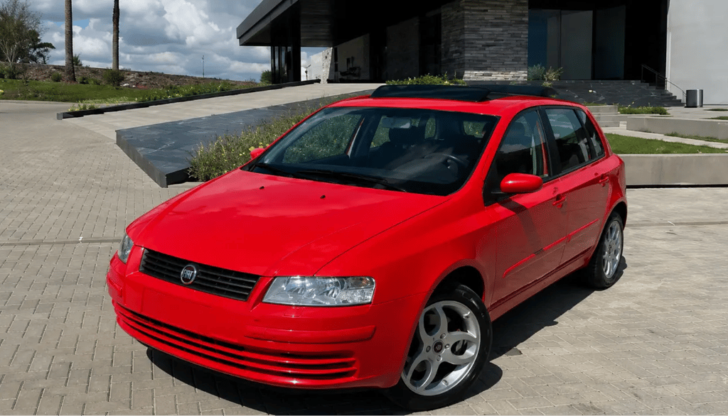 Fiat Stilo Schumacher vermelho estacionado em frente a uma casa moderna