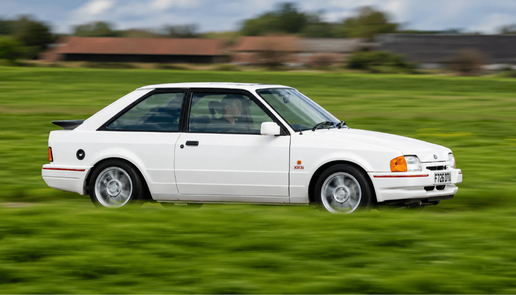 Ford Escort XR3i em movimento destaca desempenho e visual clássico esportivo