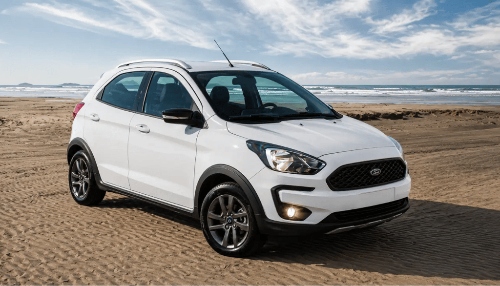 Ford Ka FreeStyle branco com vista frontal 3/4 em cenário de praia sem placa dianteira