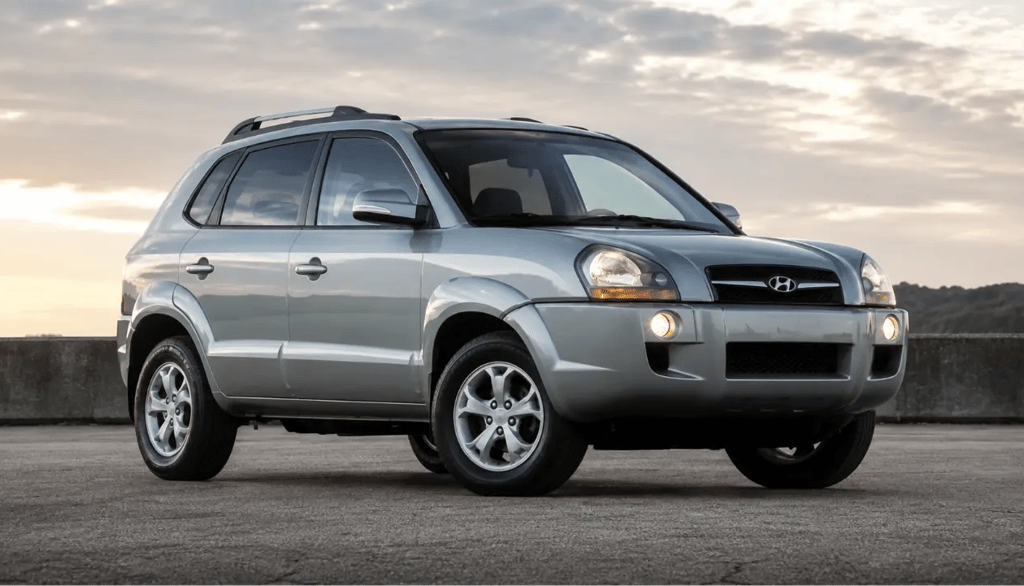 Hyundai Tucson prata visto de frente e de lado em cenário externo ao entardecer