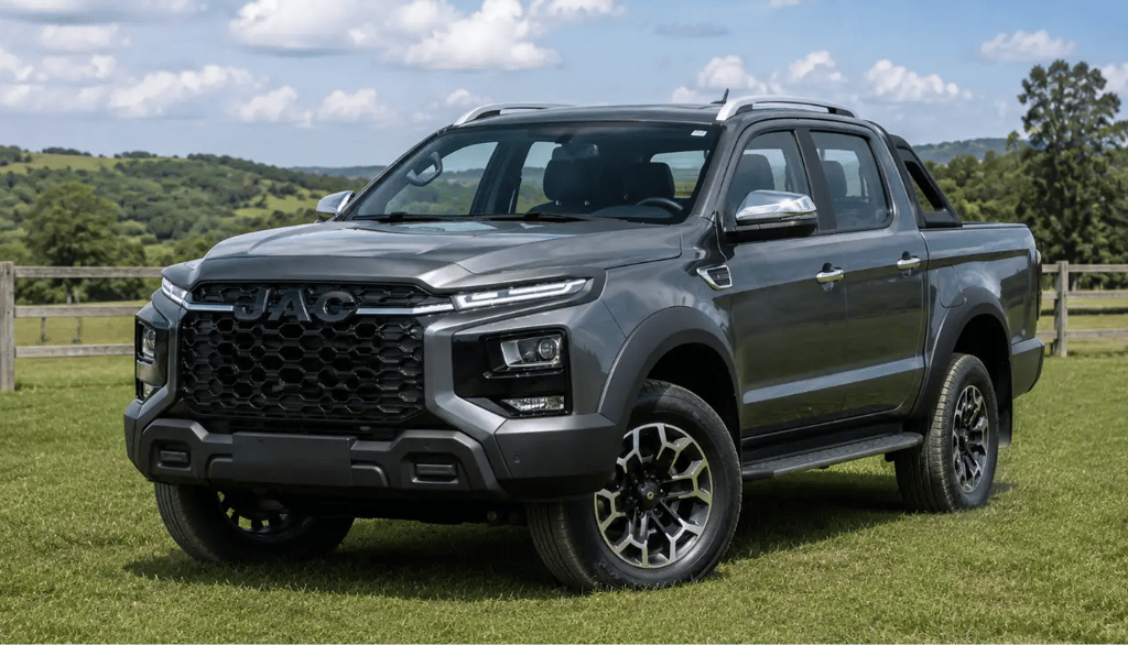 JAC Hunter HD 2025 cinza em estrada de campo com tração 4x4 e iluminação diurna