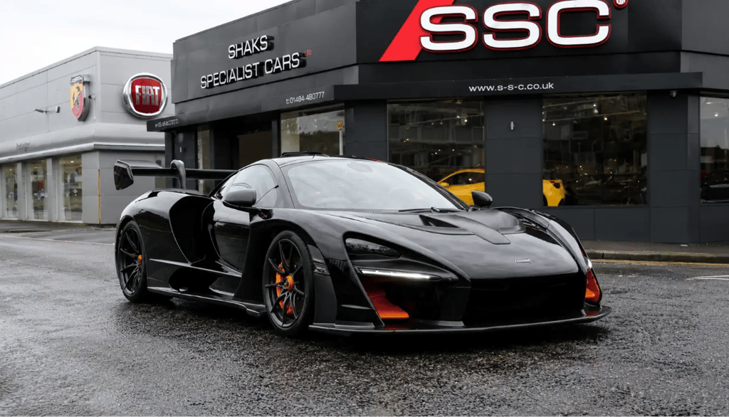 McLaren Senna preto estacionado em frente a concessionária de supercarros