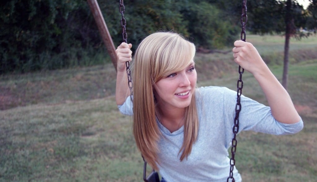 a woman sitting on a swing set