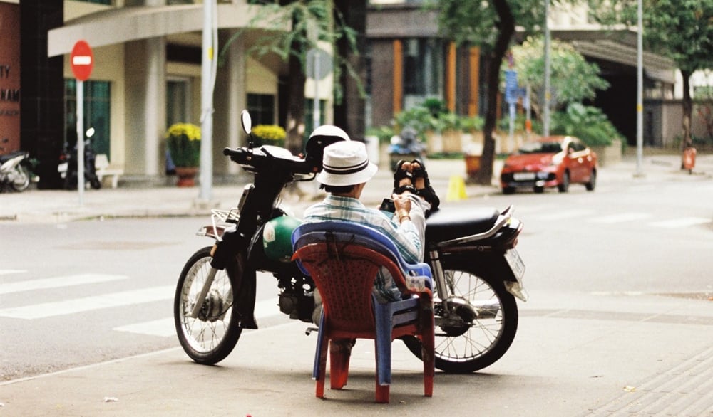 Motorbike driver resting on the street in Saigon