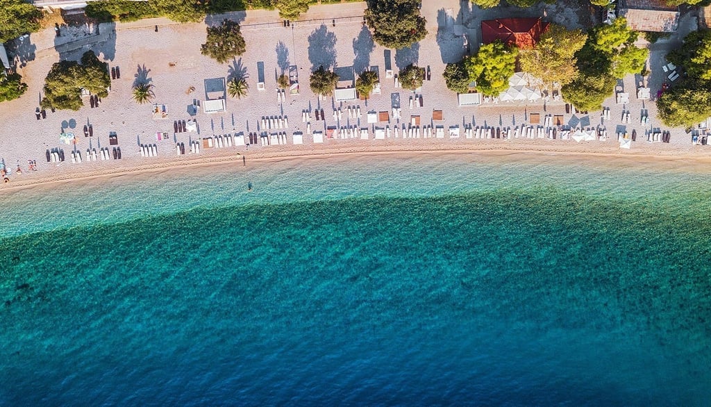 a beach with umbrellas on the beach, croatia