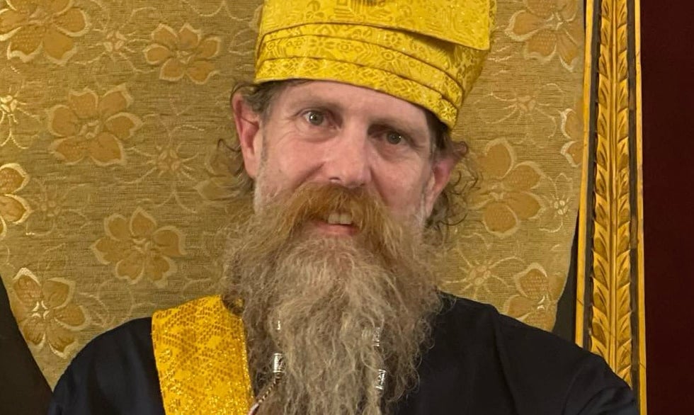 Ki Joko Moro seated on a golden chair wearing golden Indonesian ceremonial hat and sarong