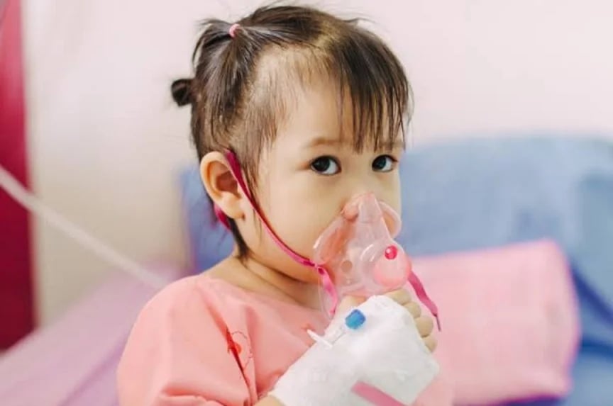 anak kecil yang sedang menghirup oksigen karena menderita pneumonia
