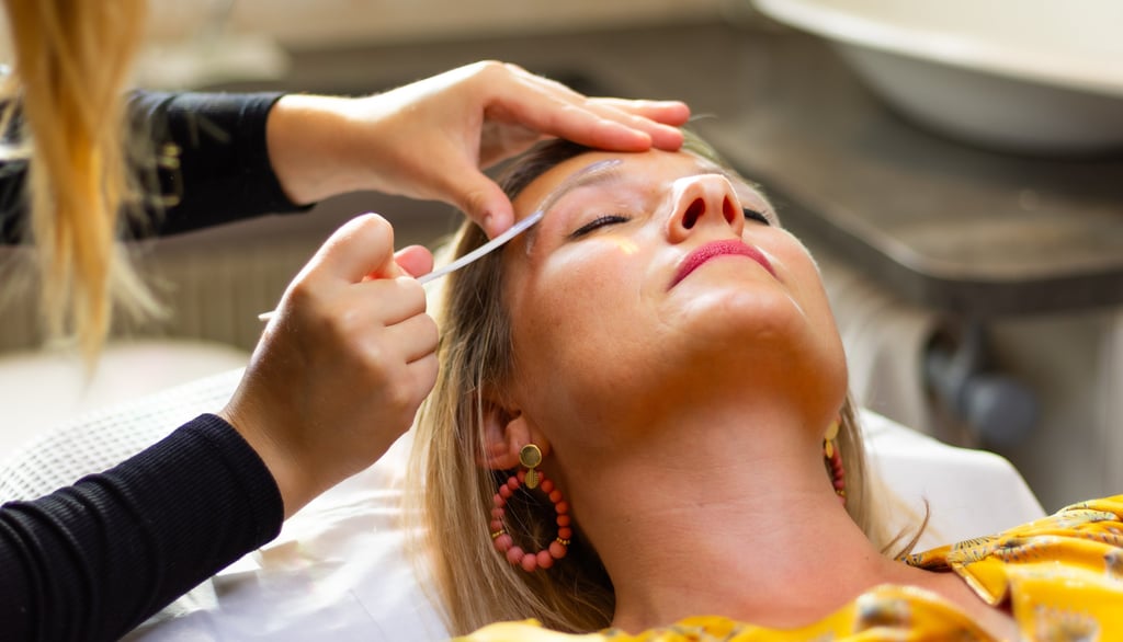 Esthéticienne professionnelle effectuant un soin d'épilation et de modelage des sourcils