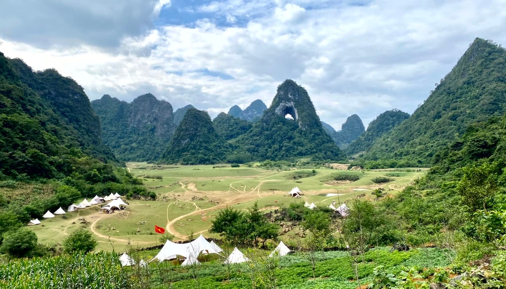 a mountain view of a valley with tents