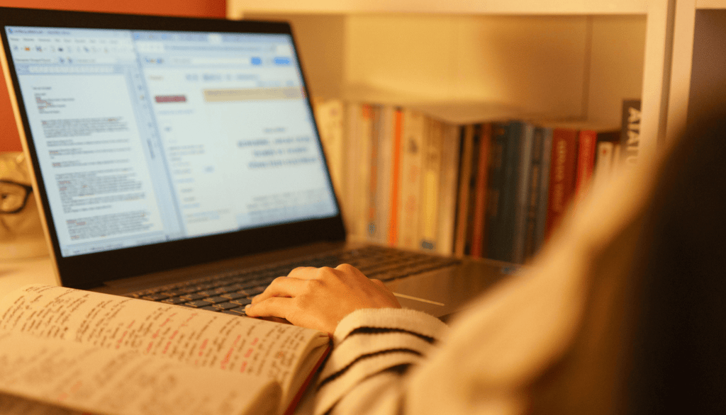 a person sitting at a desk with a book and a book