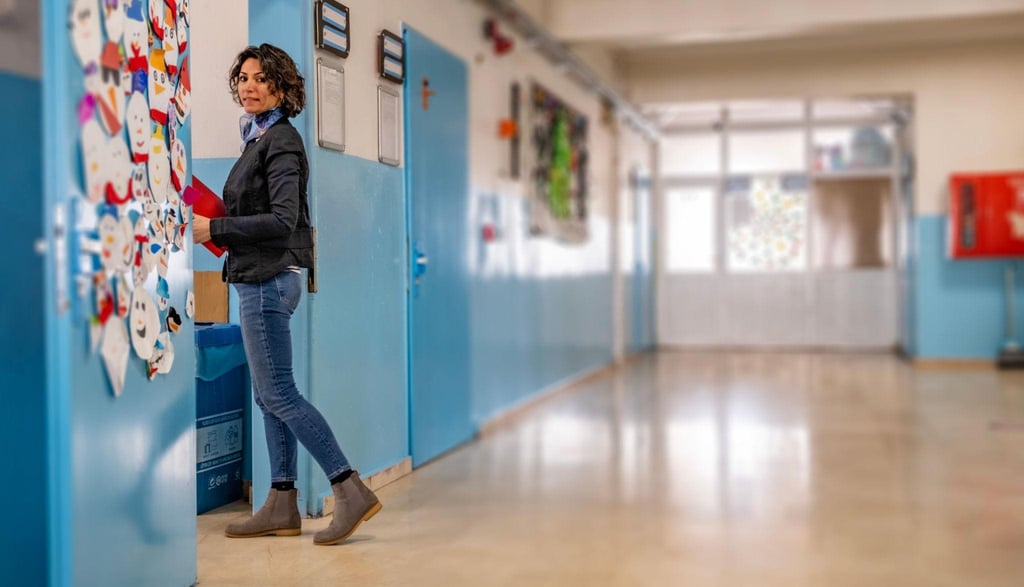 Casual young teacher walking into class room