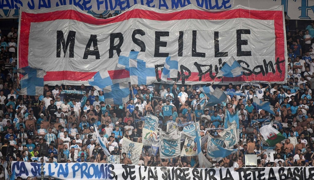 Fans von Olympique Marseille feiern im Orange Vélodrome mit Fahnen und Gesängen