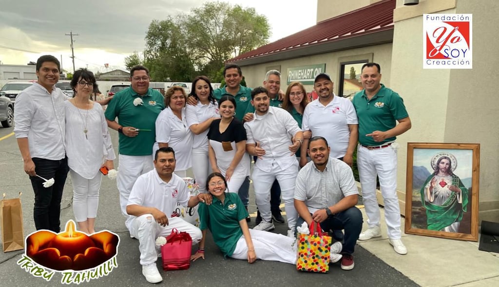 A diverse group of smiling people from the Yo Soy Creacion foundation posing together in white and green shirts.