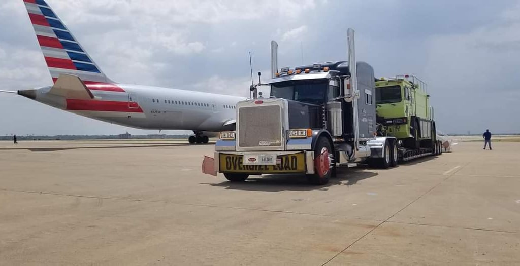 a truck with a large trailer parked on the tarmac