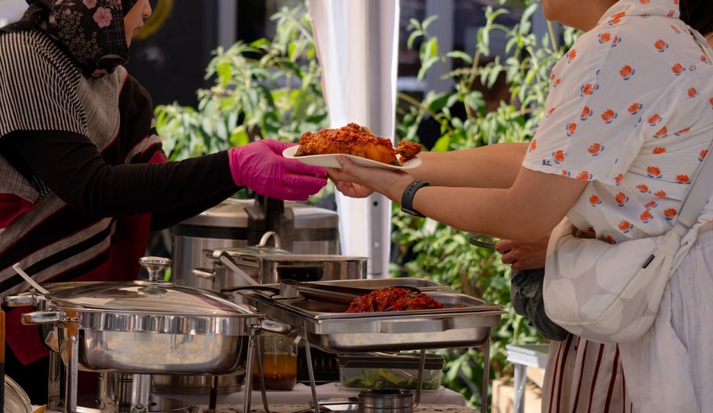 Gäste erhalten frisch serviertes indonesisches Essen auf einem Streetfood Markt