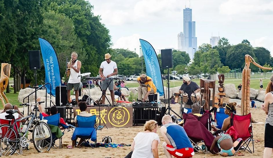 Musical performance on the beach in Chicago with saxaphonist, guitarist and DJ