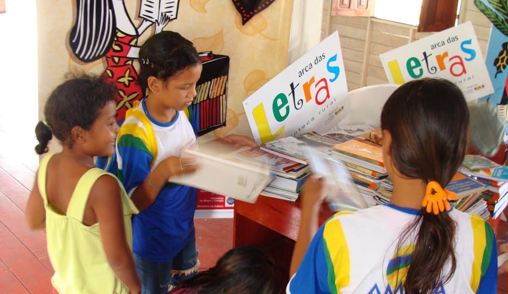 Children engaged in reading activities at the Arca das Letras rural community library in Brazil, hig