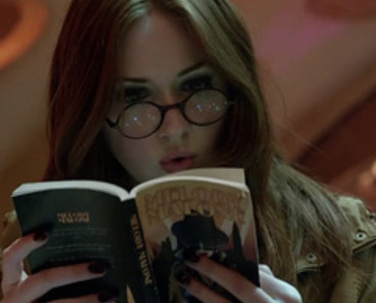 image of the character Amy Pond from the series Doctor Who reading a book inside the TARDIS