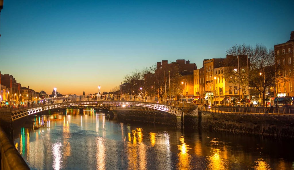 Dublin bei Nacht – Blick über den Fluss Liffey mit stimmungsvoller Beleuchtung, ideales Reiseziel für Fußballfans