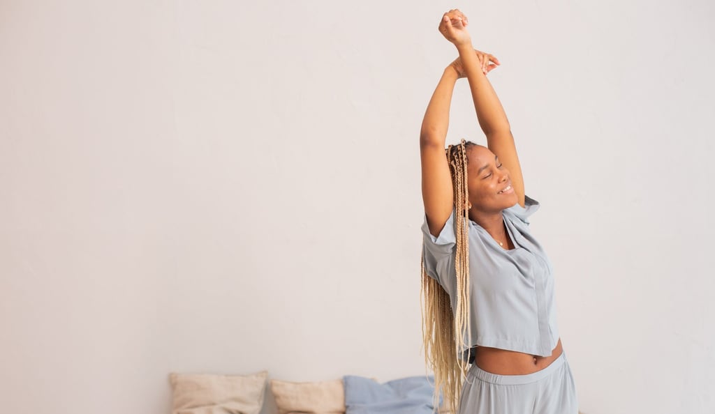 a woman in a blue shirt and pants is stretching her arms up