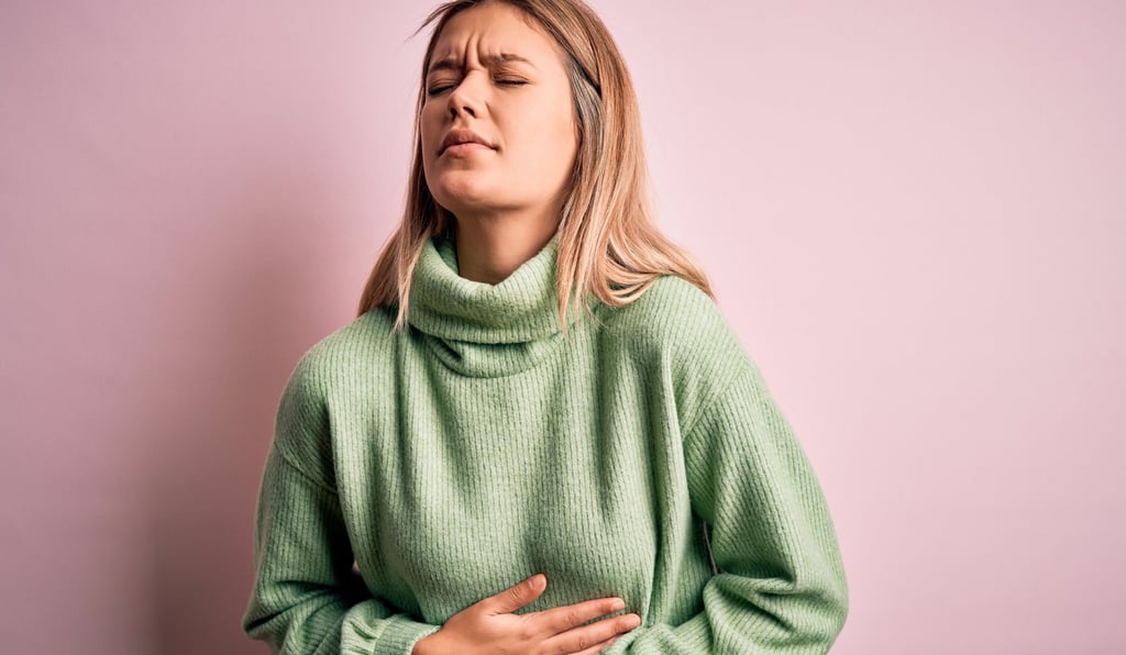 a woman with her hands on her chest and chest, holding her stomach