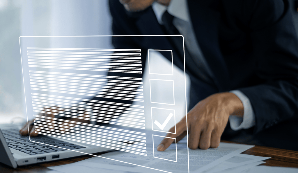 a man in a suit and tie is holding a laptop