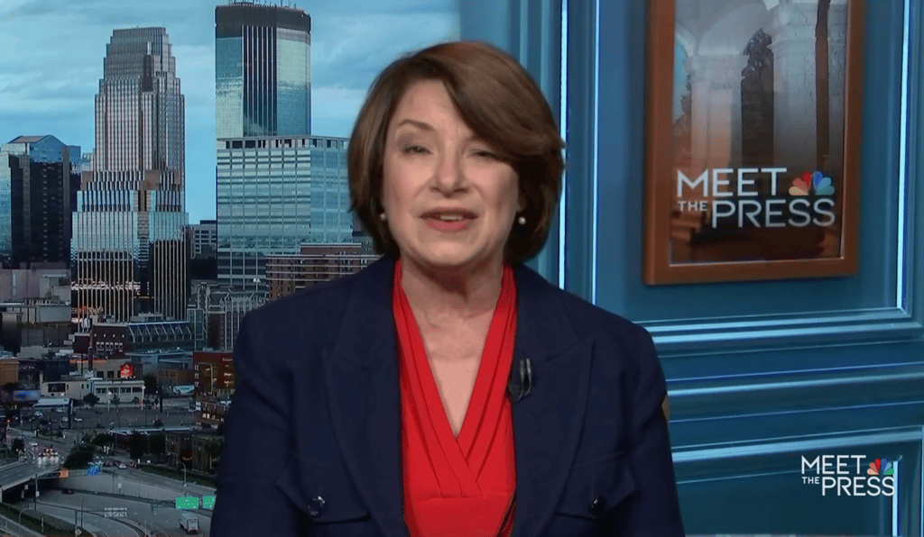 a woman in a red dress and a blue suit