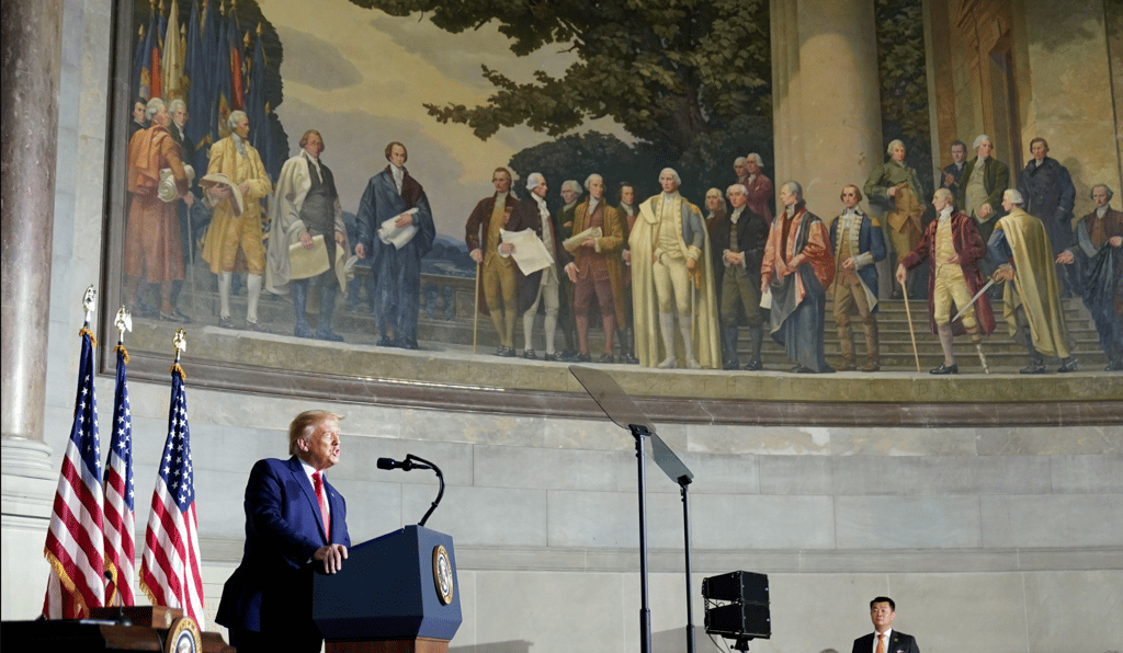 a man in a suit and tie standing at a podium with a microphone
