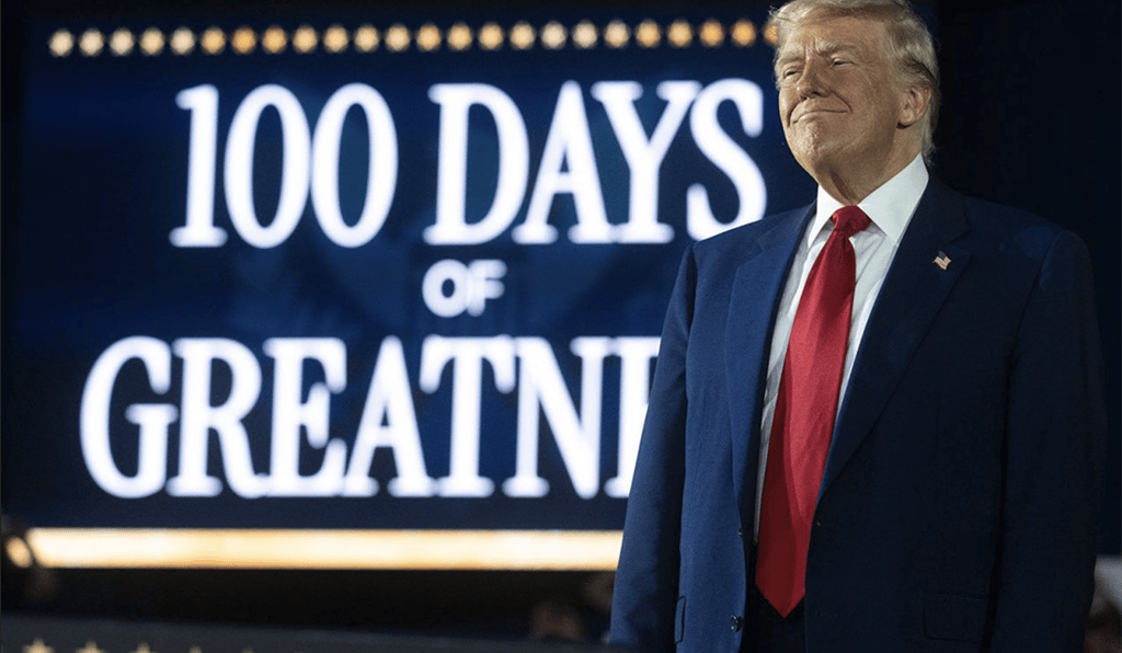 a man in a suit and tie standing in front of a sign that says,