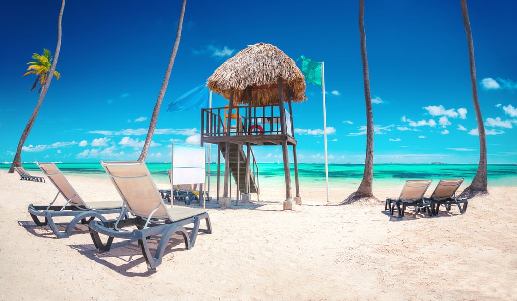 a beach with chairs and a life guard post in punta cana