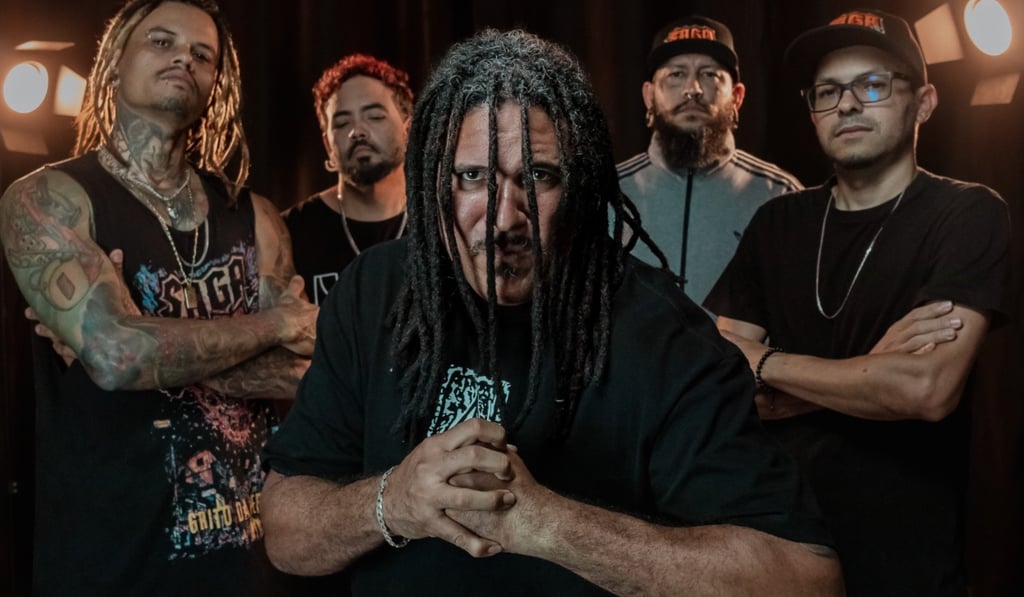 Heavy metal rock band posing with dreadlocks and tattoos in a professional group photo shoot.