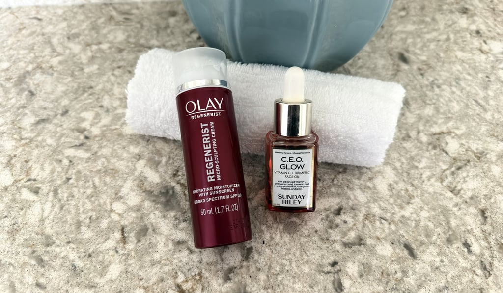 Sunday Riley C.E.O. Glow oil and Olay moisturizer with white washcloth on counter, morning skincare