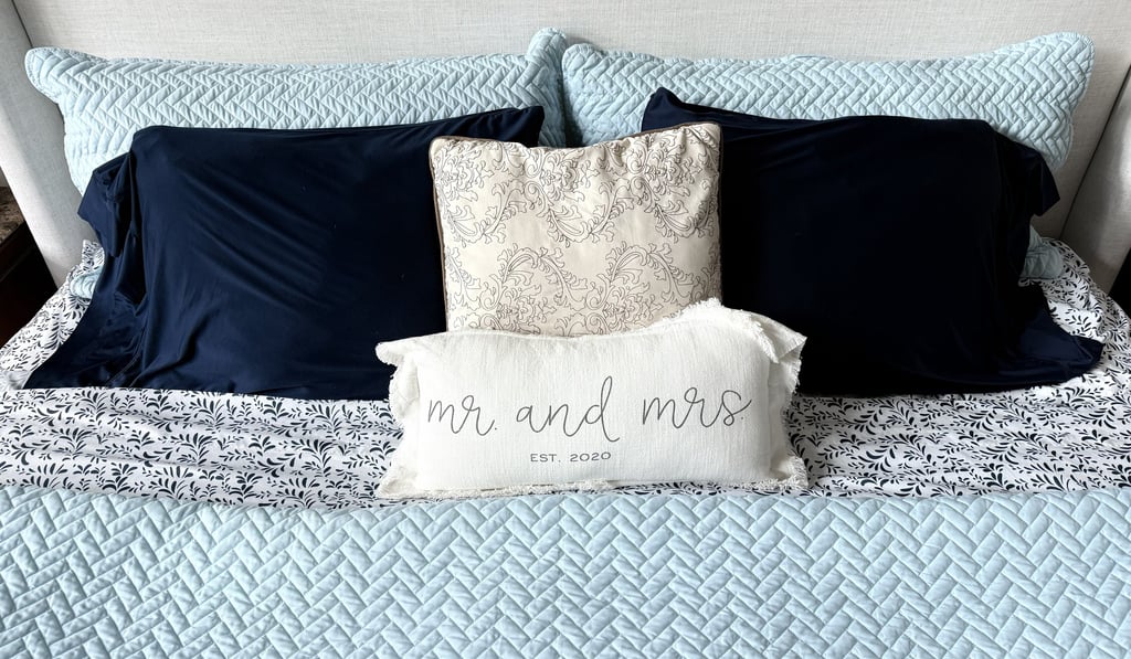 Neatly made bed with cooling pillowcases and soft sheets creating a cozy restful atmosphere