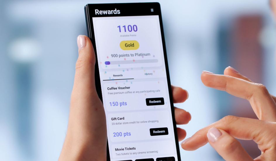 woman's hand holding phone and reviewing current points status of a loyalty and rewards program