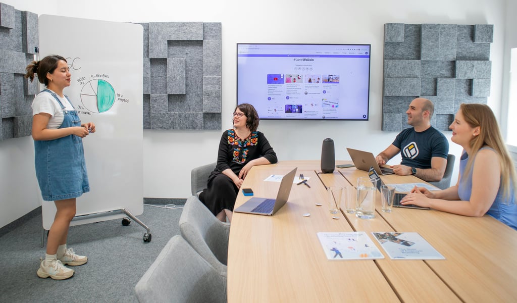 a woman in a blue dress standing in front of a large screen