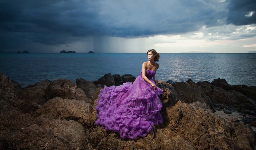 Драматичный портрет на скалах острова Фукуок в пурпурном платье