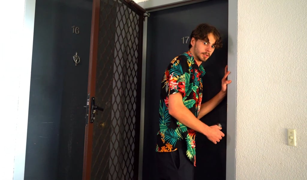a man in a hawaiian shirt is standing in a doorway