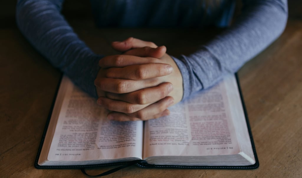 a person with a bible and praying
