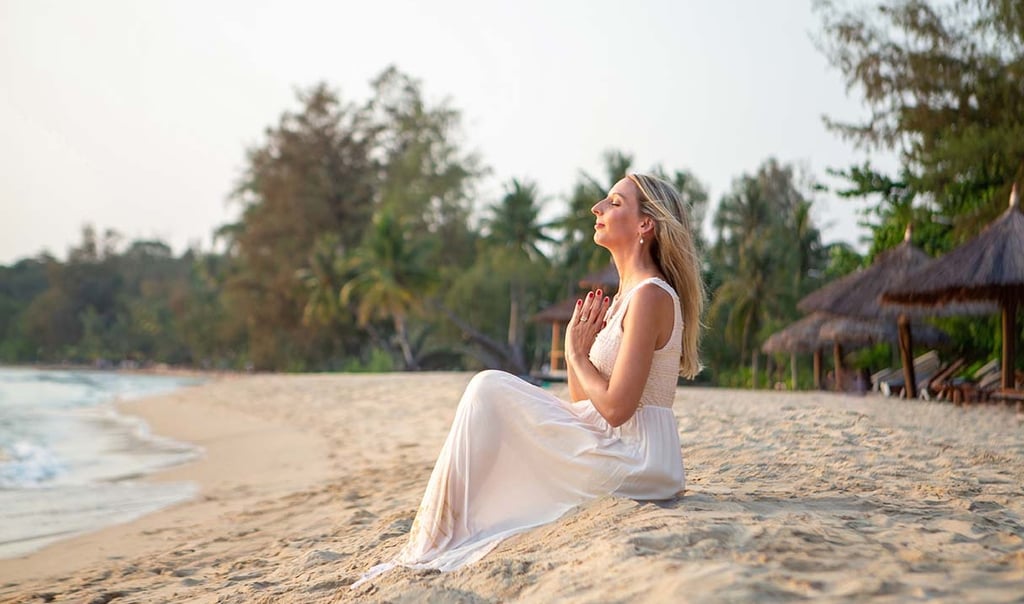 Woman sitting on the beach during a sunset personal branding photoshoot in Phu Quoc