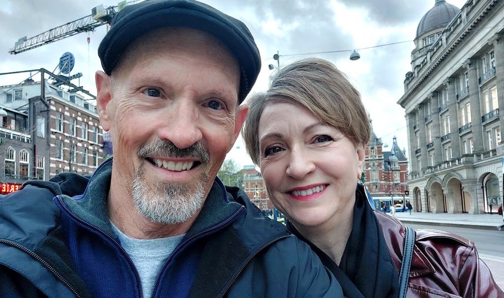 man and woman in front of buildings in amsterdam