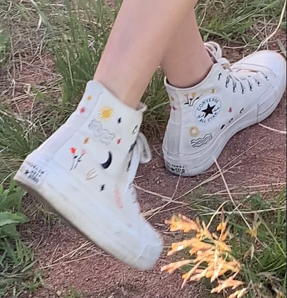 Picture of feet walking in pair of white Converse All-Stars high tops