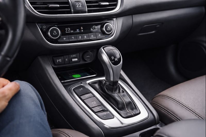 Interior de carro automático com foco no câmbio e console central em acabamento moderno.