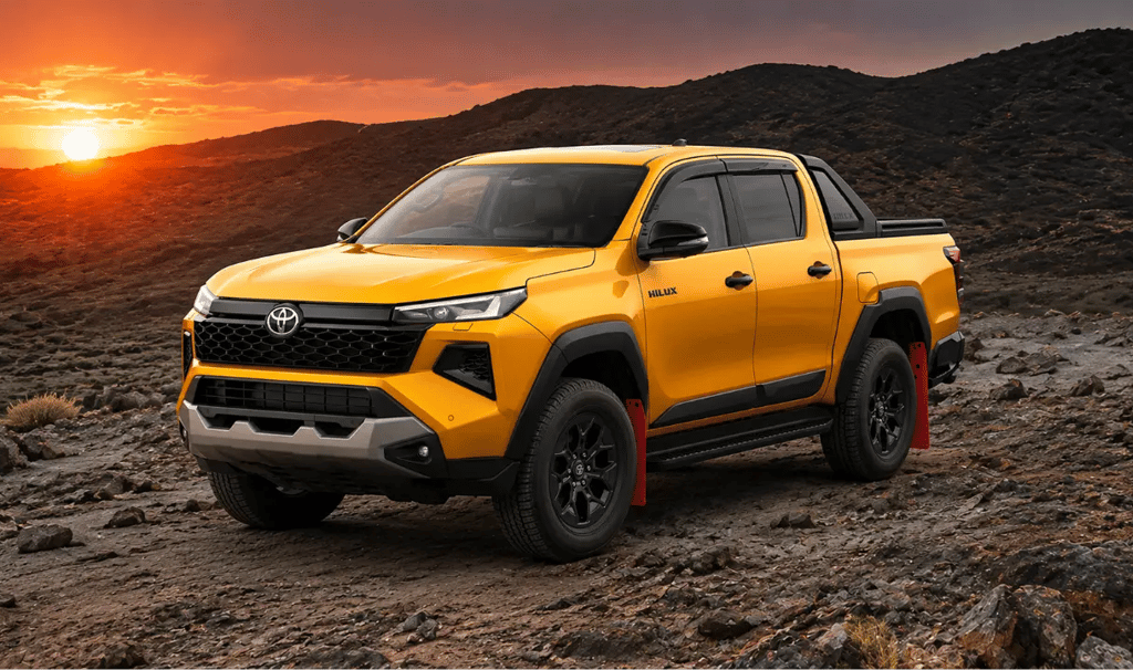 Nova Toyota Hilux com pacote esportivo em estrada rochosa ao pôr do sol