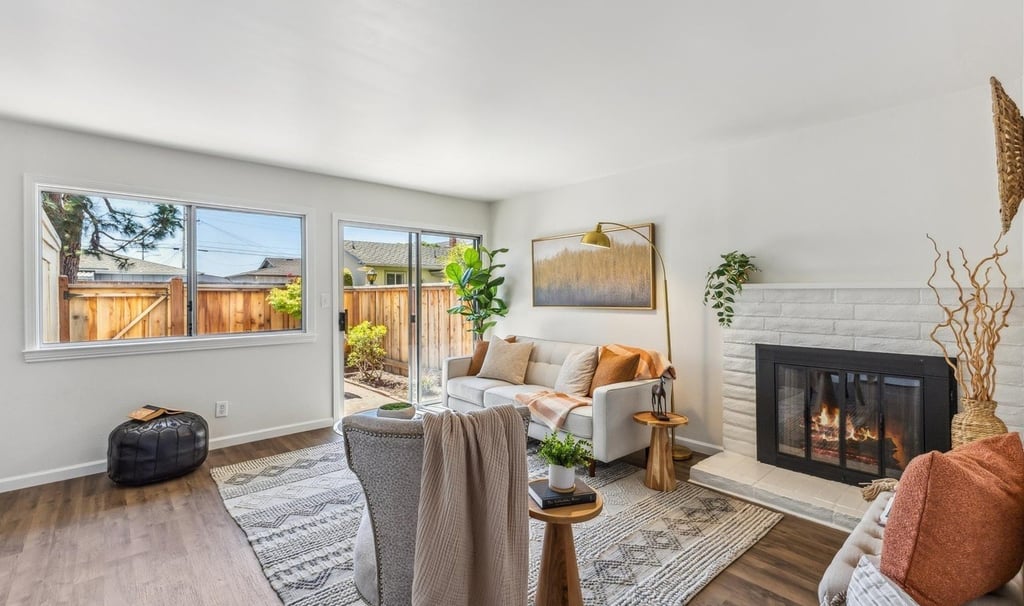 neutral color modern home staging of a living room with a fireplace, a couch, and gold color decors
