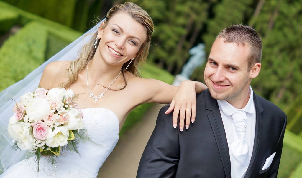 photo d'un couple de mariés souriants dans un parc à dijon