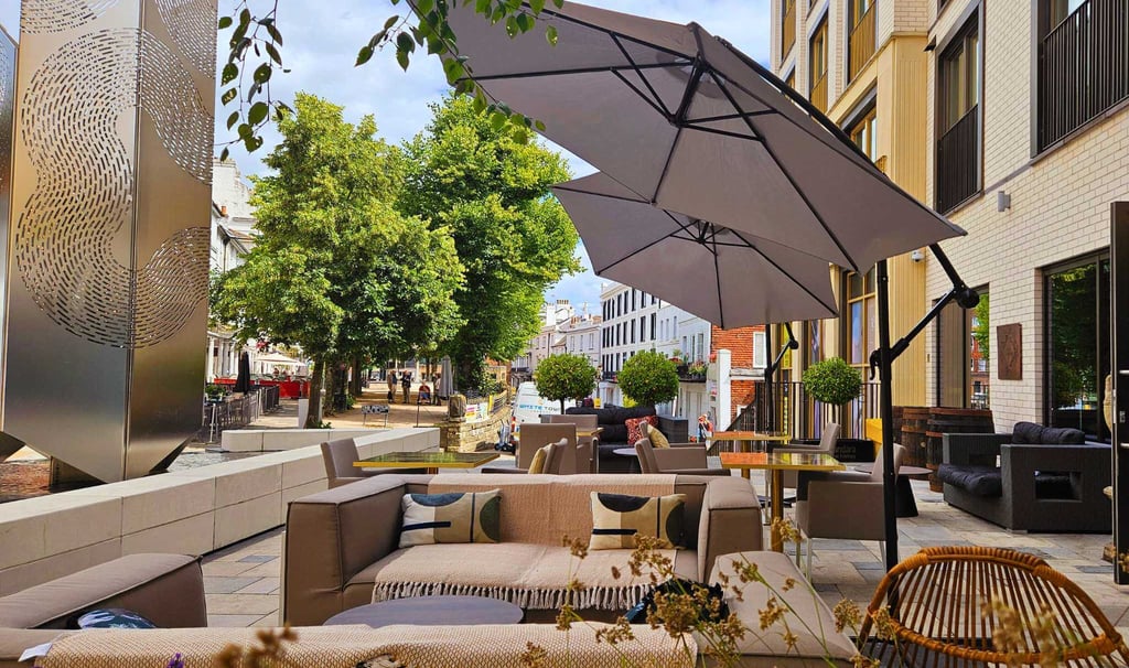 a patio with a couch and umbrella umbrella
