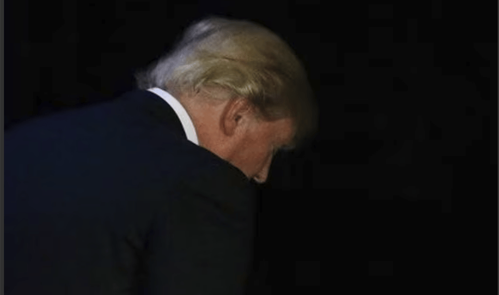 a man in a suit and tie is looking down at the ground